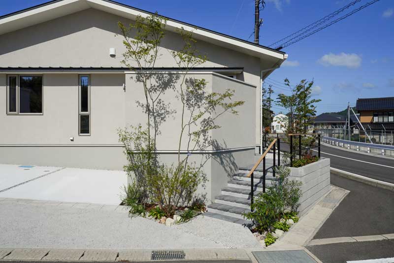 白い外壁と緑が織りなす、自然と調和した外構デザイン