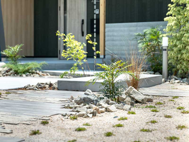 玄関へ誘う、緑と素材のリズム