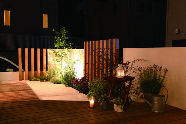 デッキとウッド立てのコーディネート。 夜間のライティングも美しく、空間に配置した植栽が、上品さを引き立てる。